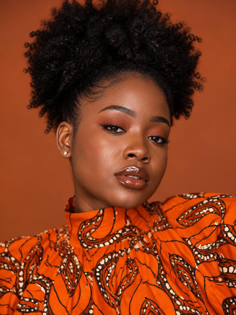 Woman with editorial makeup in an orange print top